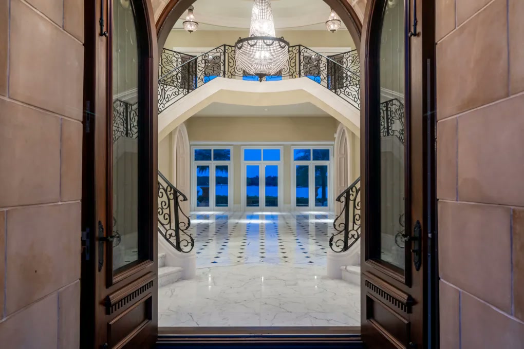 View through the front doors into the chandelier-lit foyer