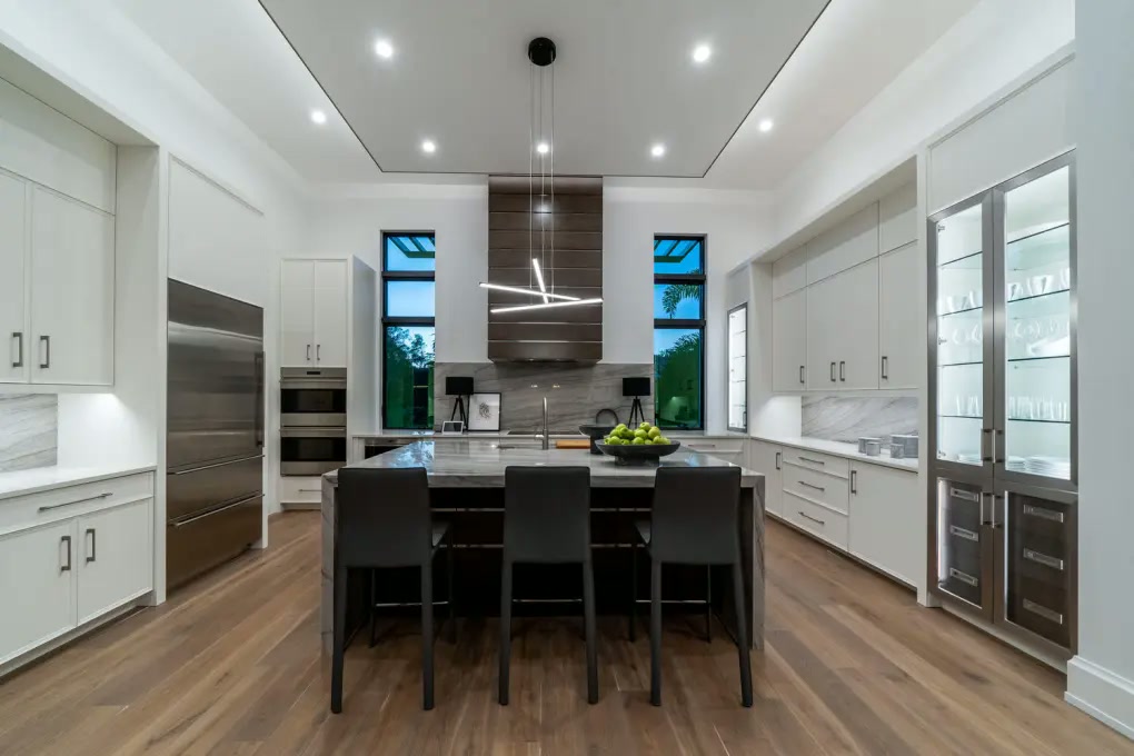 Bright modern kitchen with waterfall island and wood accent hood