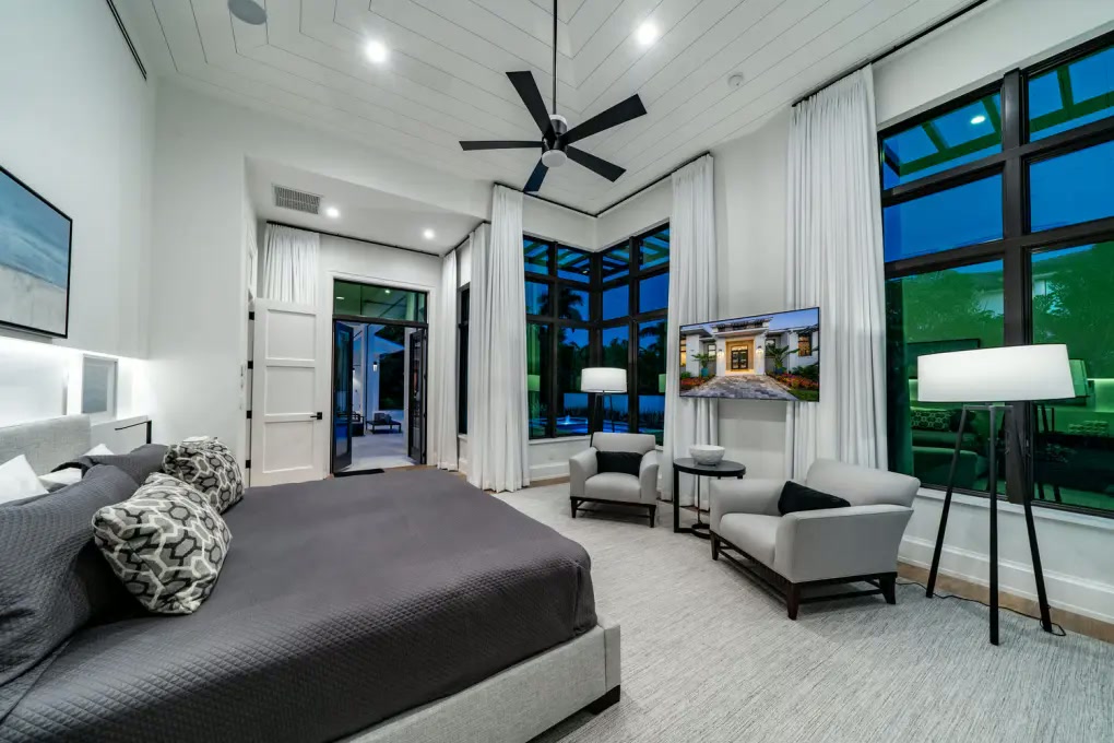 Primary bedroom with tall corner windows and paneled ceiling