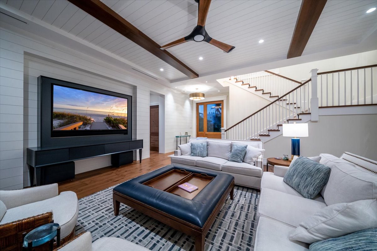 Bright great room with beamed ceiling and broad outdoor views