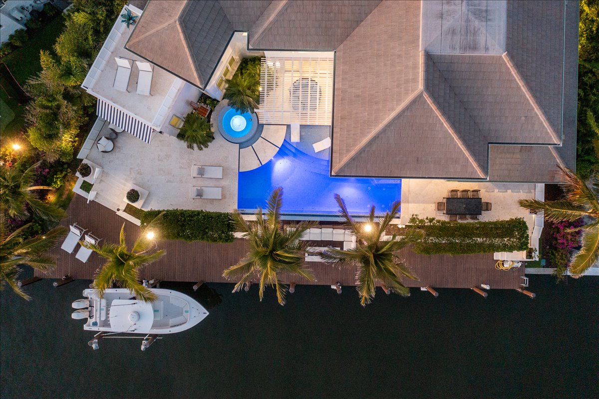 Top-down aerial showing the home, pool, dock, and canal