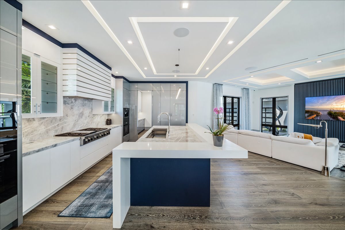 Modern white kitchen centered on a deep blue island