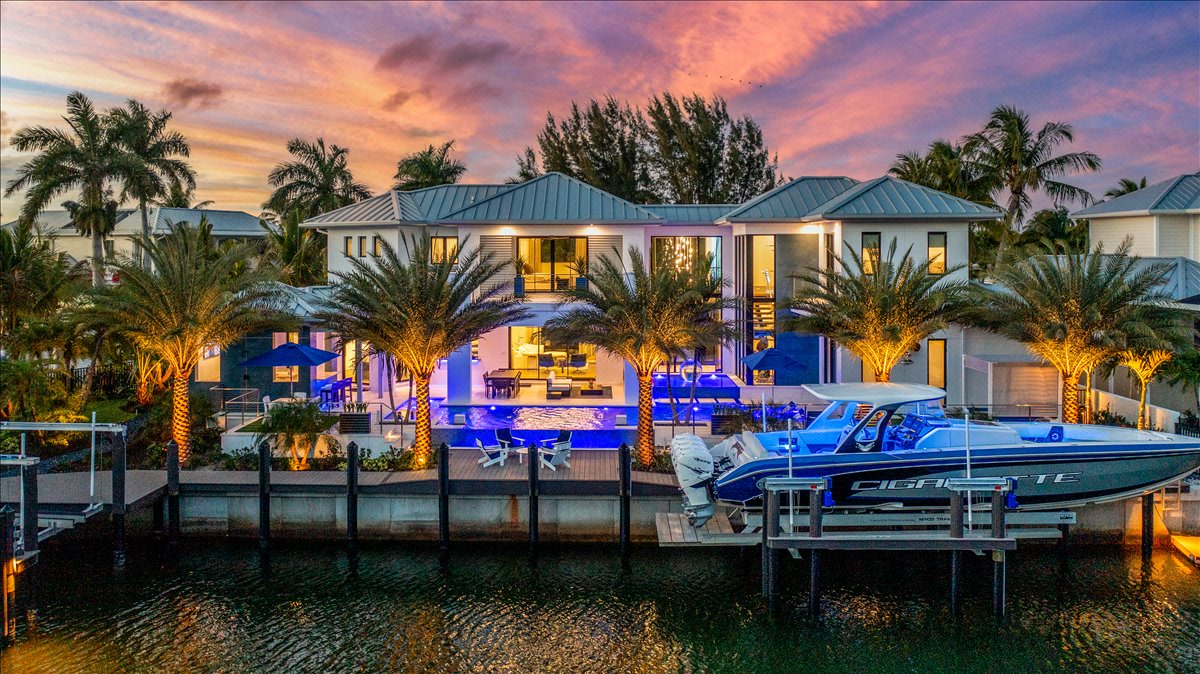 Modern waterfront estate illuminated along the canal at twilight
