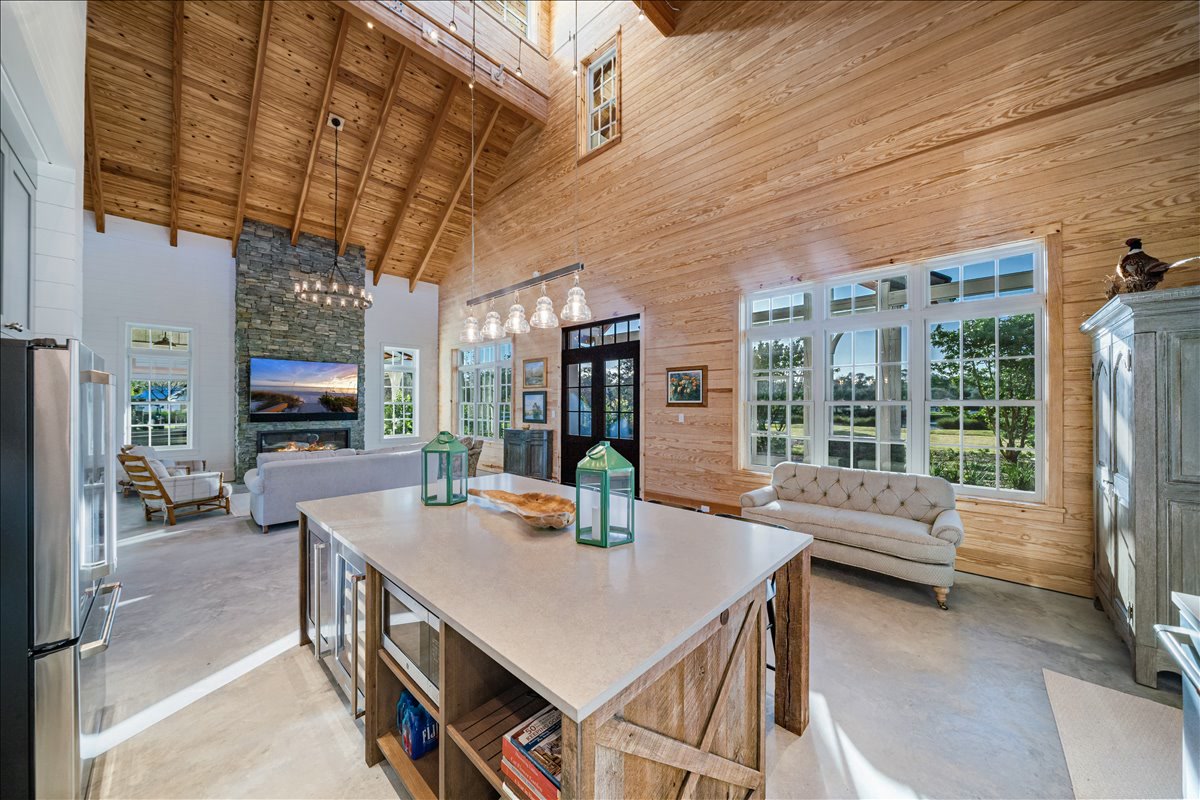 Open timber interior with kitchen island and tall windows
